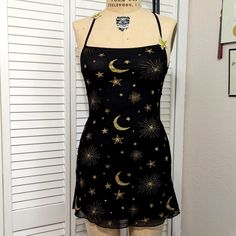 Stretchy Mesh Dress Is Fully Lined. It Has An Open Strappy Back That Is Adjustable. The Front Of The Straps Have 2 Cute Embroidered Stars That Are Sewn On. The Print Has Gold Glitter And Printing. Includes A Headband Of Glittery Gold Stars. Total Length Is About 30". Stars Dress, Embroidered Stars, Star Dress, Mesh Dress, Gold Stars, Dolls Kill, Doll Dress, Gold Glitter, Mesh