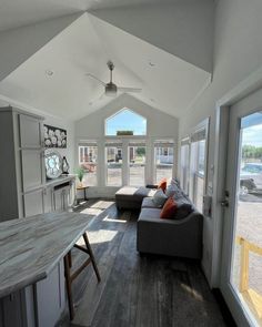 a living room filled with furniture next to a kitchen and an open concept floor plan