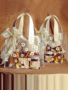 two clear bags filled with cookies and jams sitting on top of a wooden table