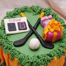 a cake decorated with green icing and sports equipment on it's side,