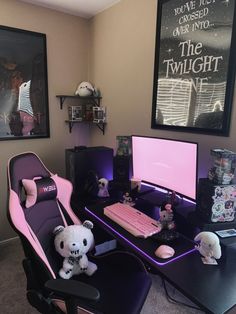 a desk with a computer, keyboard and stuffed animals on it in front of two pictures