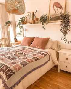 a bed sitting in a bedroom next to a dresser and potted plant on top of it