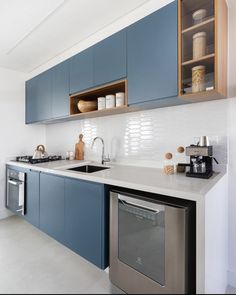 a modern kitchen with blue cabinets and stainless steel dishwasher in the center island