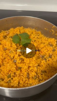 a pan filled with rice and vegetables on top of a stove