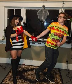 two people dressed up in costumes standing next to each other holding hands and posing for the camera