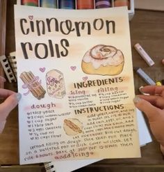 two hands holding up a poster with instructions on how to make cinnamon rolls in it