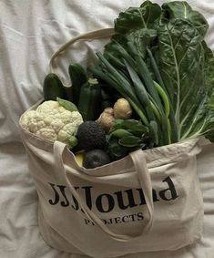 a bag full of vegetables sitting on top of a bed