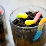 two glasses filled with dirt and candy worms