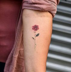 a single rose tattoo on the left arm