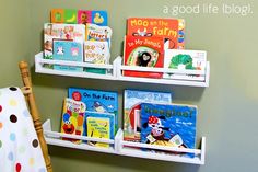 two white bookshelves with children's books on them in a child's room