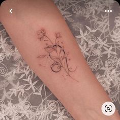 a woman's foot with a tattoo on it that has flowers growing out of it