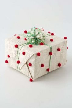 two wrapped presents with red, green and white decorations on them sitting side by side