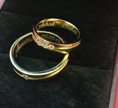 two gold wedding rings sitting in a box