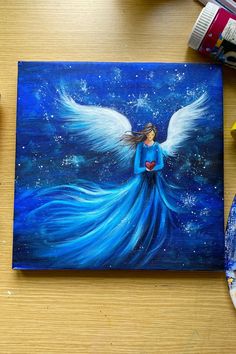 A Christmas painting on canvas of an angel with flowing blue dress and wings, holding a heart. Simple Christmas Paintings On Canvas, Christmas Art Painting, Touch Of Heaven, Soulful Art, Holding A Heart