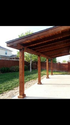 an outdoor covered patio with wooden posts