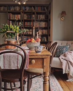 a dining room table and chairs with bookshelves in the background