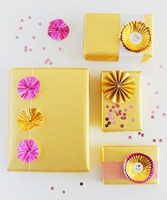 three yellow boxes with pink and gold decorations on them next to confetti cones