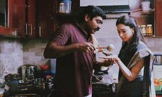 a man and woman standing in a kitchen preparing food