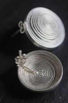 These beautiful spiral earrings are a slightly modernized version of typical hill tribe spiral jewelry - eternal spiral is a motif that represents the never-ending cycle of life and is commonly used by the tribe people of greater Mekong region. They are made of 2.5 mm thick silver strip, tightly rolled into a spiral, silver posts are soldered at the back. Stoppers are in sterling silver. All our silver products are created in 95-98% Silver which is typical of the Thai Karen hill-tribe artisans, Spiral Jewelry, Hill Tribe Silver, Cycle Of Life, Spiral Earrings, The Tribe, Decorative Bowls, Thailand, Stud Earrings, Bowl