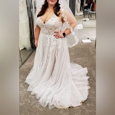 a woman in a wedding dress posing for the camera with her hands on her hips