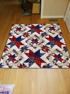 a red, white and blue quilt on the floor