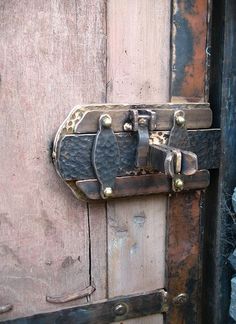 an old wooden door with metal latches on it