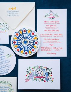 the wedding stationery is decorated with colorful designs