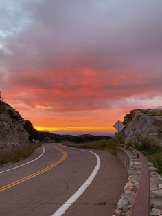 an empty road with a sunset in the background