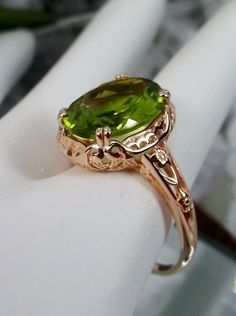 "Natural Green Peridot Ring Edward Design#70z (smaller version) Rose Gold plated Sterling Silver Custom Made Inspired by Edwardian jewelry of the early 1900s, I now offer this lovely Antique reproduction ring in sterling silver rose gold plated. This gorgeous ring is set with a stunning Natural Green Peridot gemstone. This genuine Peridot has excellent color and clarity. The oval cut Peridot is 12mm (9/16th of an inch) Long by 10mm Wide (3/8th\"). The ring sits 6mm off the finger. The inside of Cute Engagement Rings, Edwardian Jewelry, Gorgeous Ring, Jewelry Fashion Trends, Leaf Jewelry, Ring Rose Gold, Peridot Gemstone, Peridot Ring, Green Peridot