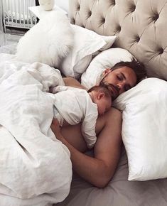 a man is laying in bed with his head on the pillow and looking at the camera