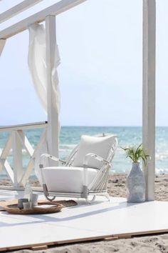 a white chair sitting on top of a sandy beach