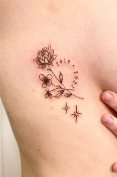 a woman's stomach with a flower tattoo on it and stars around the side