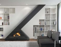 a modern living room with a fireplace and bookshelves