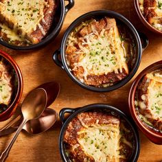 several casserole dishes with cheese and meat in them sitting on a table next to utensils