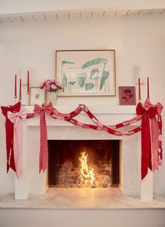 a fireplace decorated with red ribbon and flowers