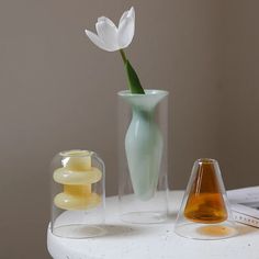 there is a vase with a flower in it on the table next to other items