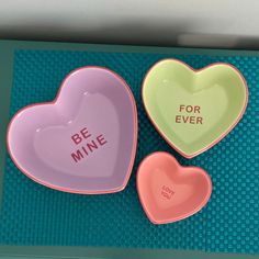 three heart shaped dishes with the words be mine and for ever written on one bowl