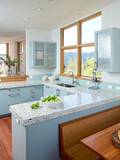 an image of a kitchen with blue cabinets and white counter tops in the middle of it