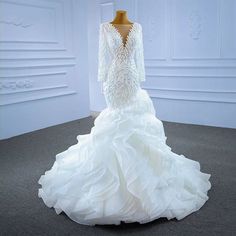 a white wedding dress on display in a room