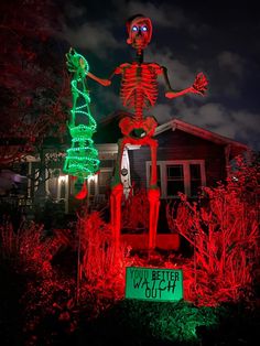 a skeleton statue in front of a house with christmas lights on it's lawn