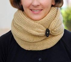 a woman wearing a knitted cowl with a button in the middle and a scarf around her neck