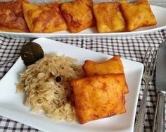 two white plates with food on top of them next to silverware and utensils