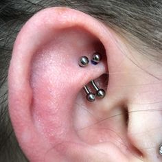 an ear with three piercings attached to it's middle part and two smaller ones on the other side