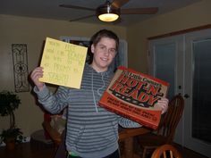 a young man holding up two boxes with writing on them