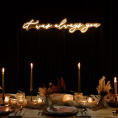 there is a table set with candles and place settings for the dinner guests to eat