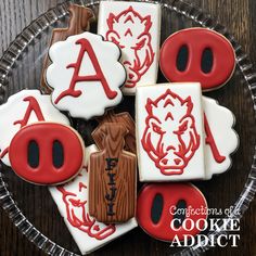 decorated cookies in the shape of letters and numbers on a glass plate with red icing