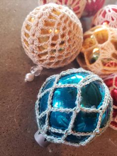 three balls are sitting on the floor next to each other and one is crocheted