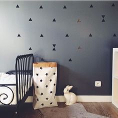 a baby's room with black and white wall decals on the walls, including a crib