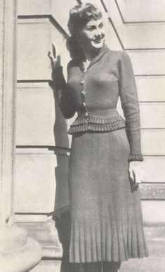 an old black and white photo of a woman wearing a dress with pleated skirt