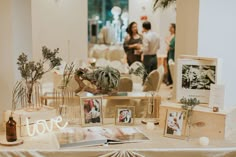 a table topped with pictures and plants on top of it